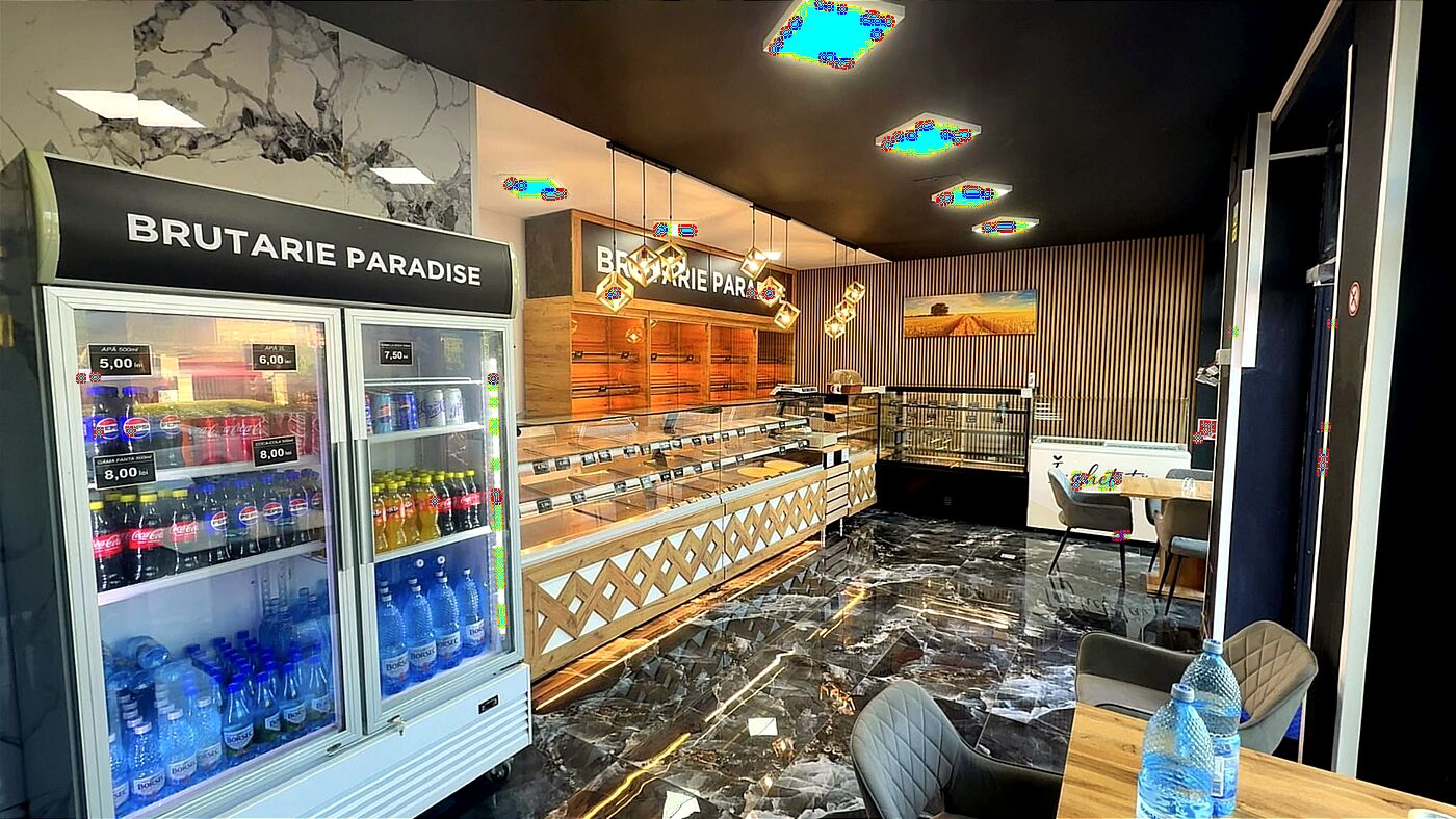 Interiorul magazinului Paradise din Timișoara, cu vitrină de produse și frigider de băuturi